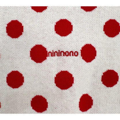 Detailed shot of the red nininono logo embroidery on the back of the cardigan.