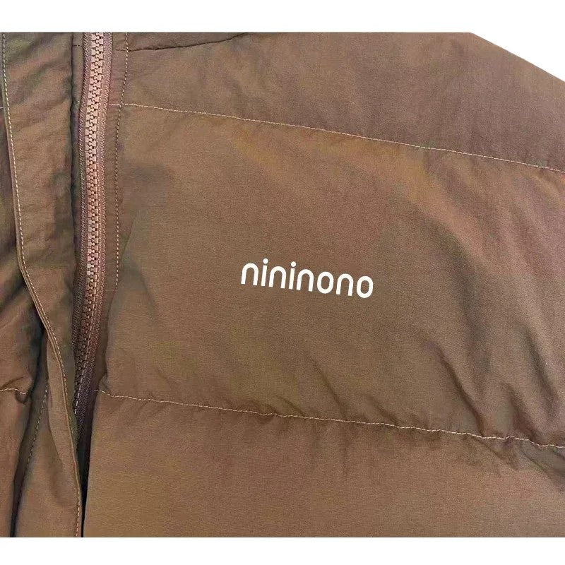Detailed shot of the minimal nininono branding on the chest of the Earth Brown jacket.