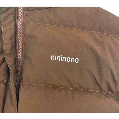 Detailed shot of the minimal nininono branding on the chest of the Earth Brown jacket.