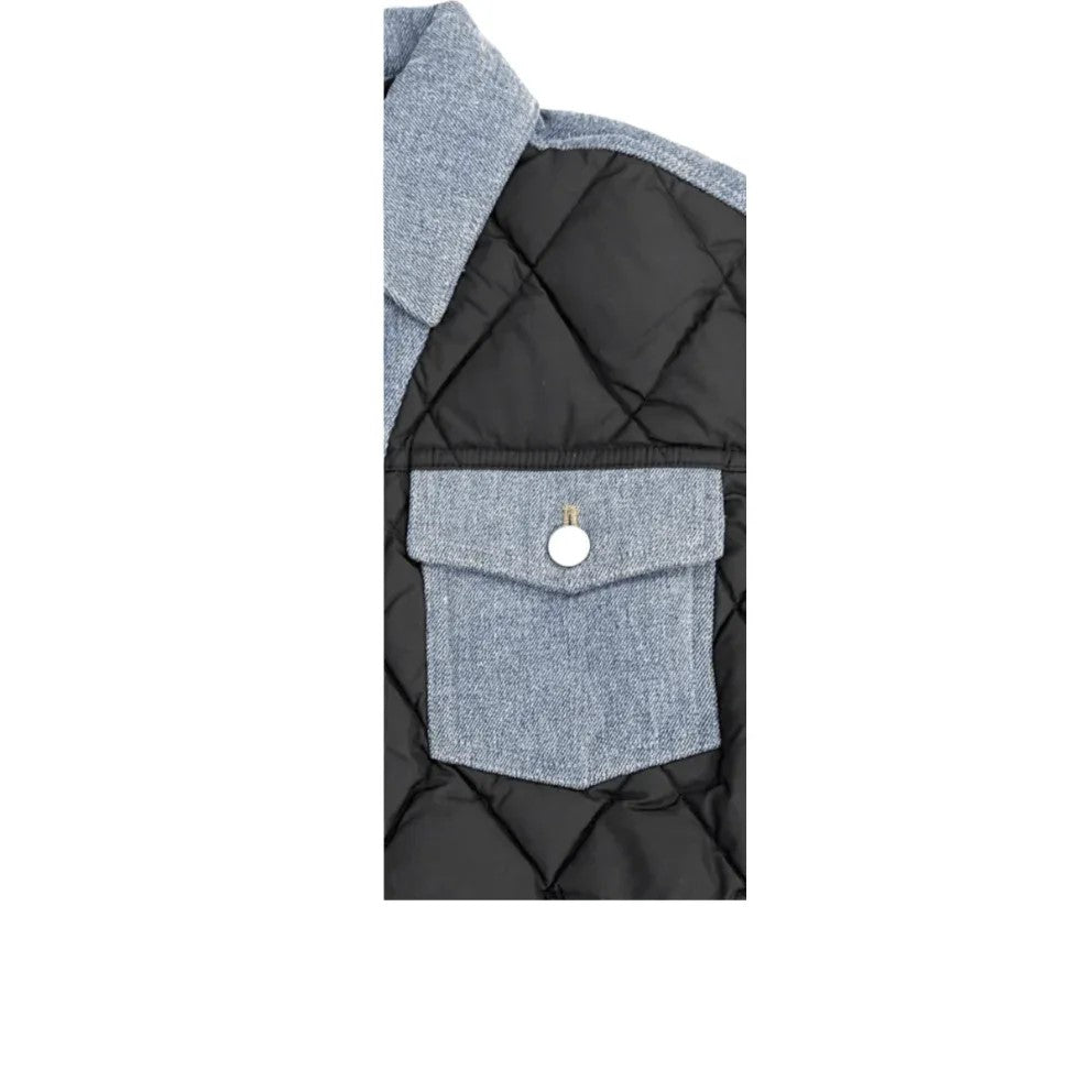 Close-up of the functional denim chest pocket and clean stitching on the black quilted body.