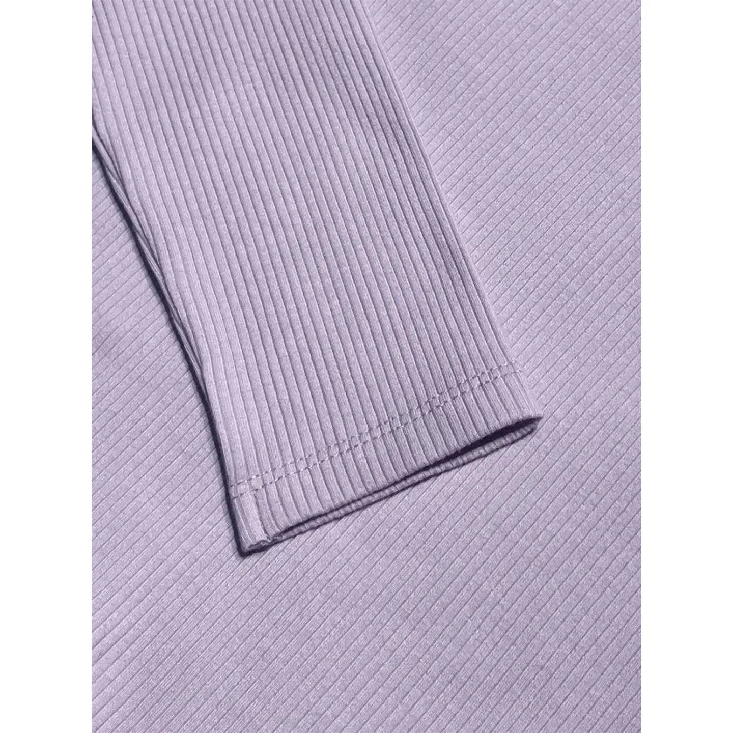 Detail of the finely stitched sleeve cuff and the thick 290 GSM dusty purple cotton fabric.