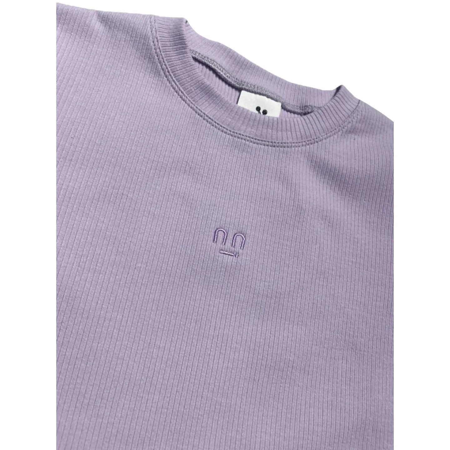 Close-up of the ribbed crew neckline and the tonal purple smiley face embroidery on the Ogender cropped tee.