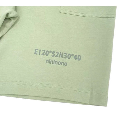 Close-up of the 3D silicone graphic on the hem of the Sage Green shorts.