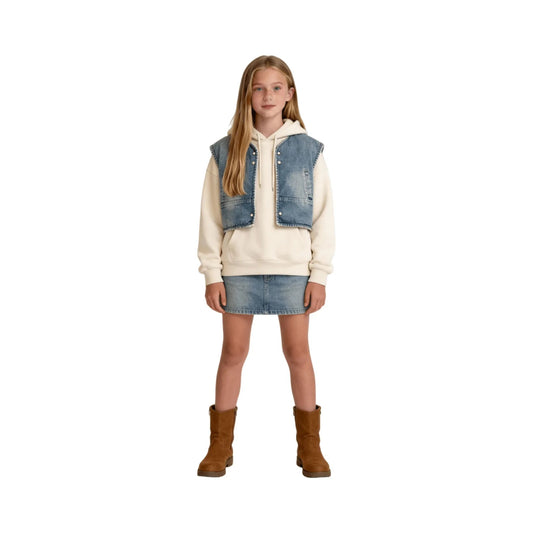 A teen girl styling the oversized cropped denim vest over a hoodie for a trendy winter outfit.