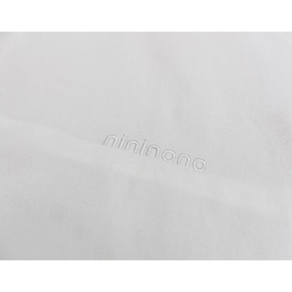 Detailed shot of the subtle white "nininono" embroidery on the left chest of the white shirt.