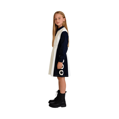Side view of a girl wearing the dark navy and white color-block polo dress, showcasing the structured silhouette and the bold "nono" graphics.